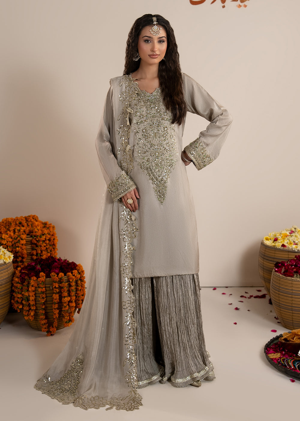 Woman wearing a traditional outfit with floral decorations in the background